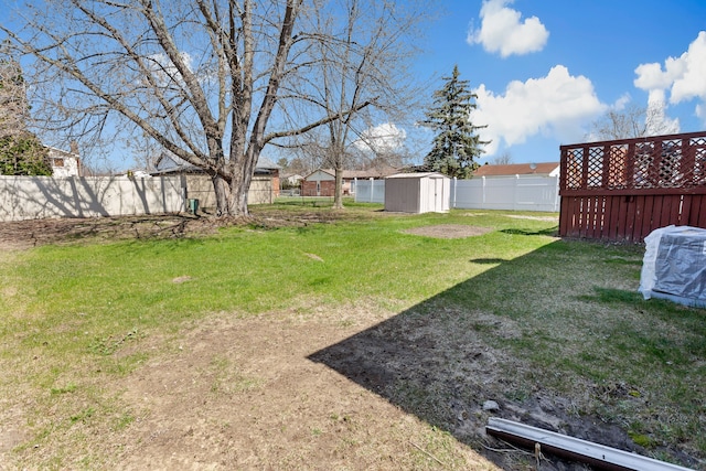 view of yard featuring a fenced backyard, an outbuilding, and a shed