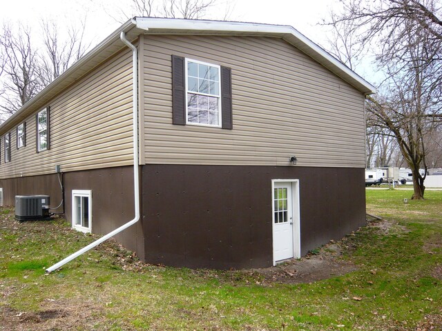 view of side of property with a yard and cooling unit