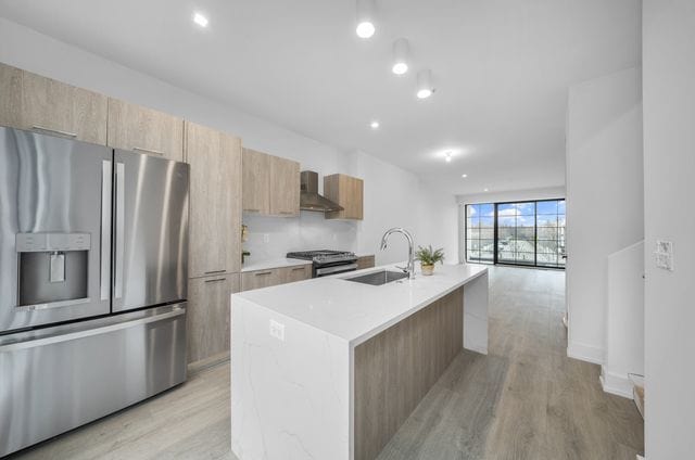 533 E Harrison Ave Unit 30, Royal Oak, MI 48067 - kitchen featuring stainless steel appliances, a sink, wall chimney exhaust hood, and modern cabinets