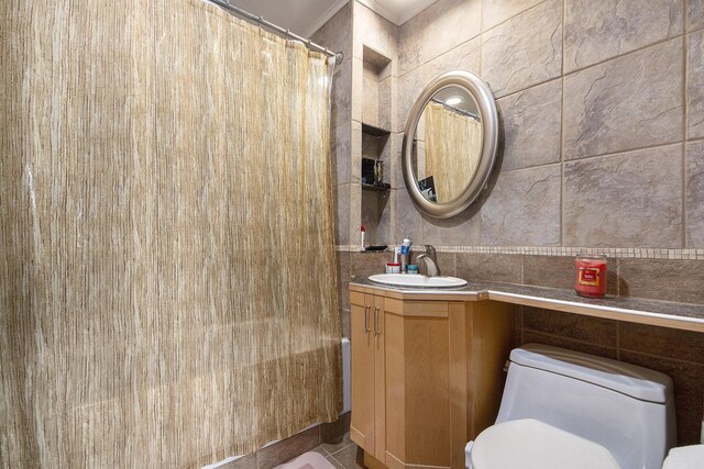 3942 Harmon Dr, Fremont, MI 49412 - full bath featuring crown molding, vanity, toilet, a shower with shower curtain, and tile walls