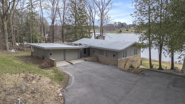3942 Harmon Dr, Fremont, MI 49412 - view of front facade with a water view, driveway, and a garage
