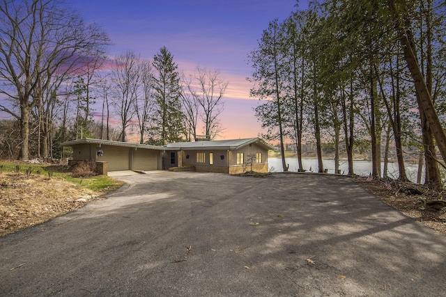 3942 Harmon Dr, Fremont, MI 49412 - view of front facade with a water view, aphalt driveway, and an attached garage