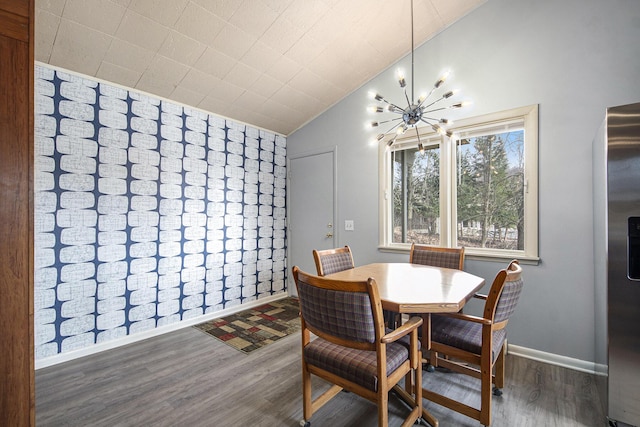 3942 Harmon Dr, Fremont, MI 49412 - dining area featuring wood finished floors, an inviting chandelier, baseboards, and vaulted ceiling