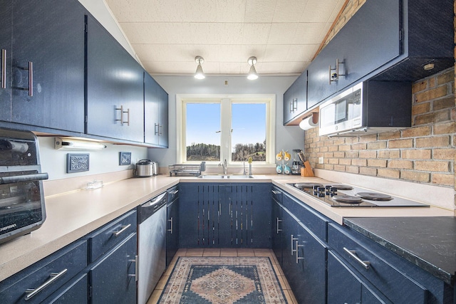3942 Harmon Dr, Fremont, MI 49412 - kitchen with blue cabinets, light countertops, a sink, stainless steel appliances, and backsplash