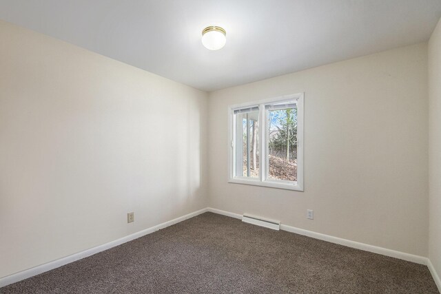 3942 Harmon Dr, Fremont, MI 49412 - spare room featuring dark carpet, baseboards, and a baseboard heating unit
