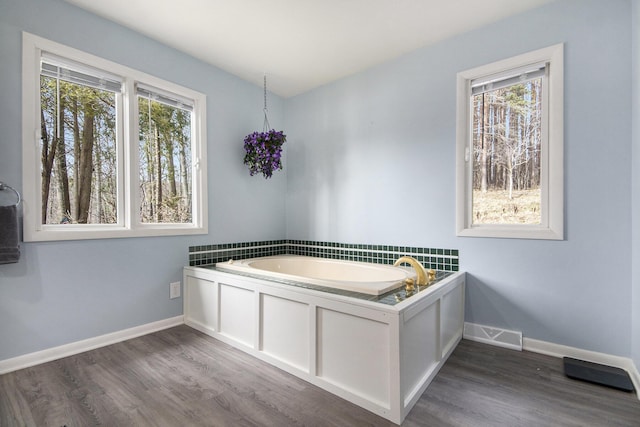 3942 Harmon Dr, Fremont, MI 49412 - bathroom with a bath, visible vents, baseboards, and wood finished floors