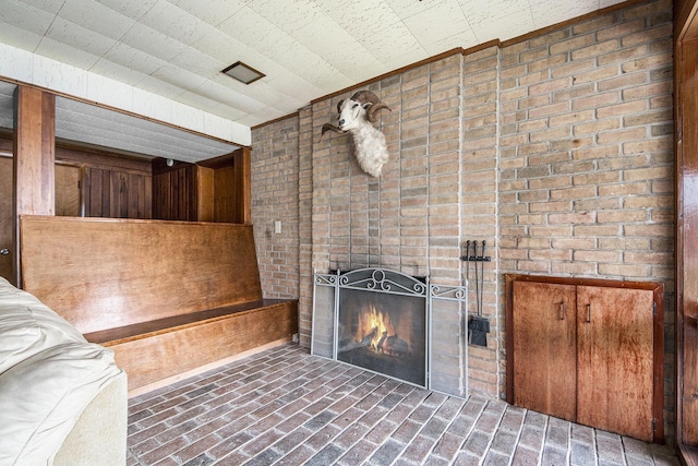 3942 Harmon Dr, Fremont, MI 49412 - unfurnished living room with brick floor and a brick fireplace