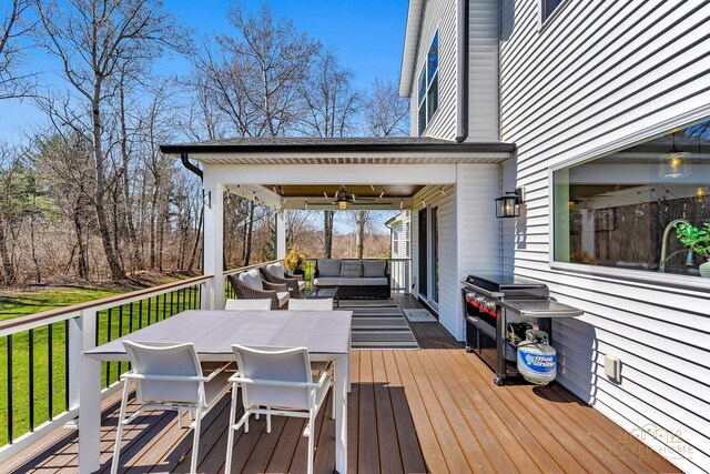 wooden terrace featuring outdoor dining space, outdoor lounge area, and ceiling fan