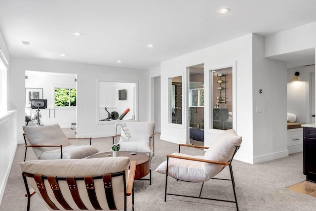 living room with visible vents, baseboards, recessed lighting, and light colored carpet