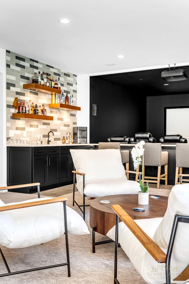 bar featuring recessed lighting, a sink, wet bar, and backsplash