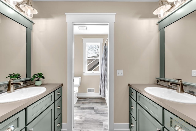 bathroom with two vanities, visible vents, and a sink