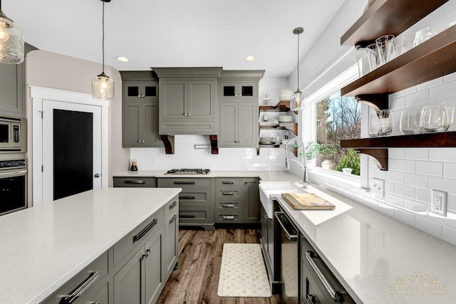 kitchen featuring tasteful backsplash, gray cabinets, dark wood-style floors, open shelves, and stainless steel appliances
