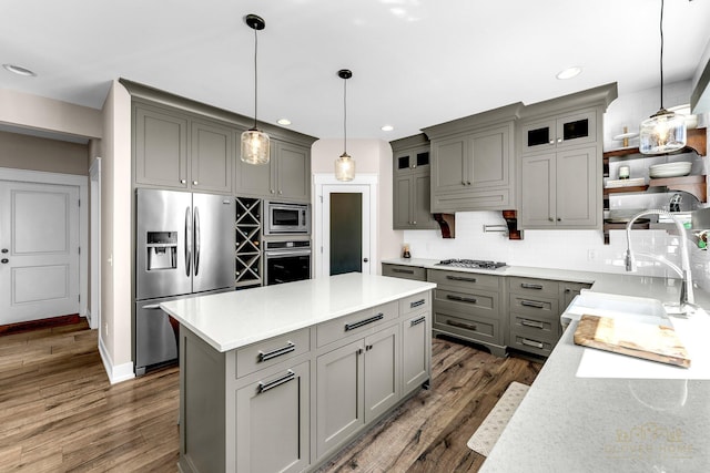 kitchen with dark wood-type flooring, appliances with stainless steel finishes, decorative backsplash, and gray cabinetry