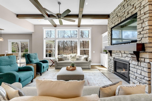 living room featuring baseboards, a stone fireplace, ceiling fan, beamed ceiling, and coffered ceiling