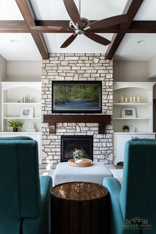 living room featuring beam ceiling, ceiling fan, coffered ceiling, and a fireplace
