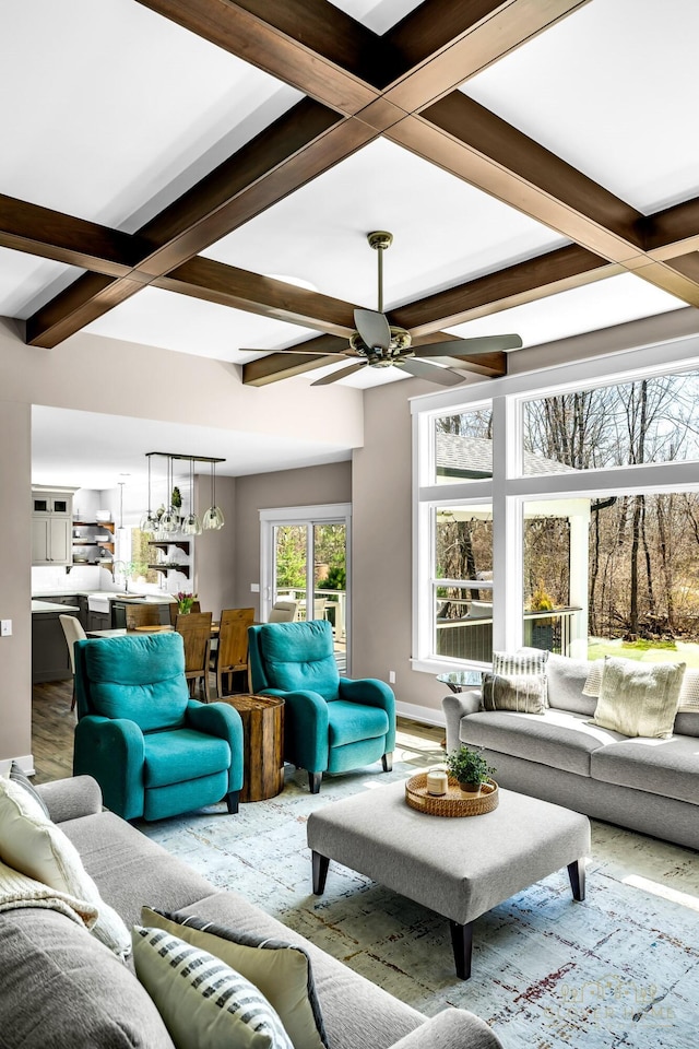 living room with ceiling fan, baseboards, beam ceiling, and coffered ceiling