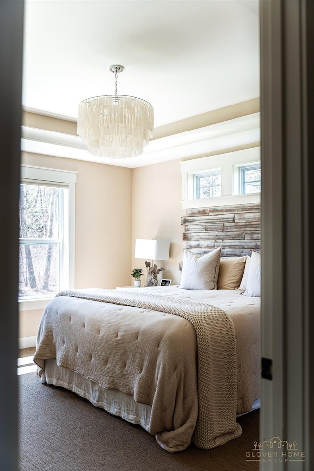 bedroom with carpet flooring and a notable chandelier