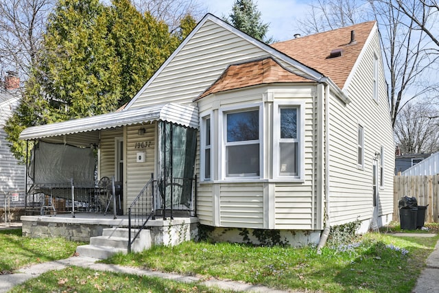 bungalow-style house featuring fence, a porch, and a shingled roof