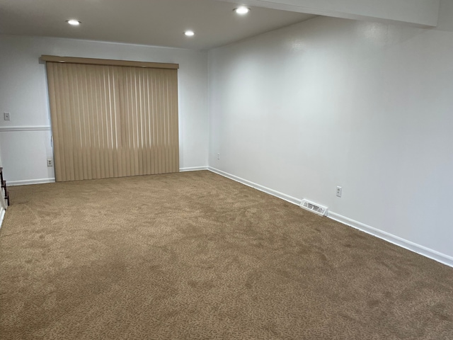 empty room with dark carpet, baseboards, visible vents, and recessed lighting