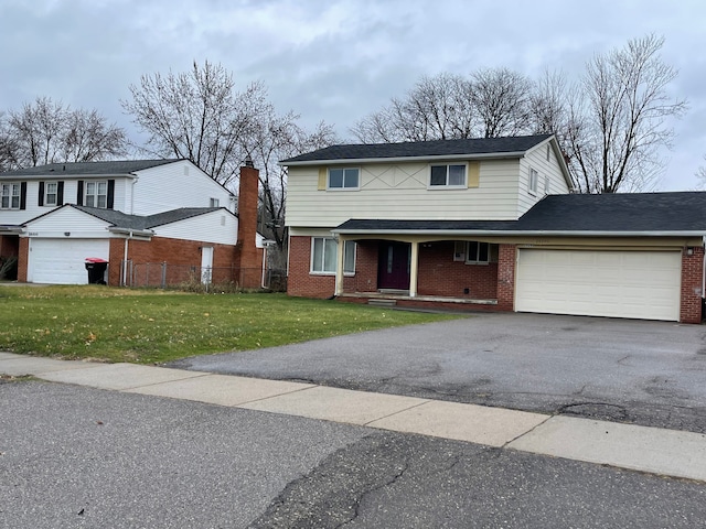 traditional-style house with driveway, a front yard, brick siding, a garage, and fence