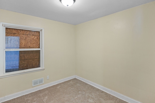 carpeted spare room with baseboards and visible vents