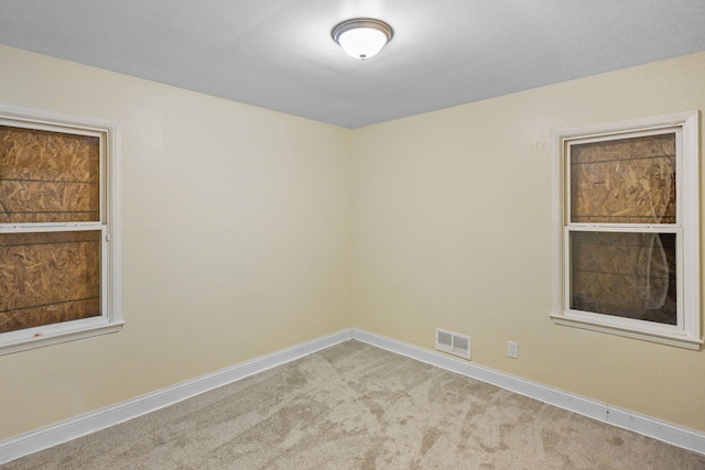 unfurnished room featuring visible vents, baseboards, and carpet floors