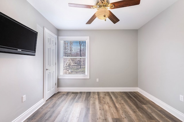 unfurnished room featuring ceiling fan, baseboards, and wood finished floors