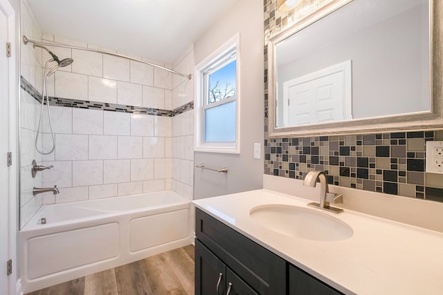 full bathroom featuring decorative backsplash, shower / bath combination, wood finished floors, and vanity