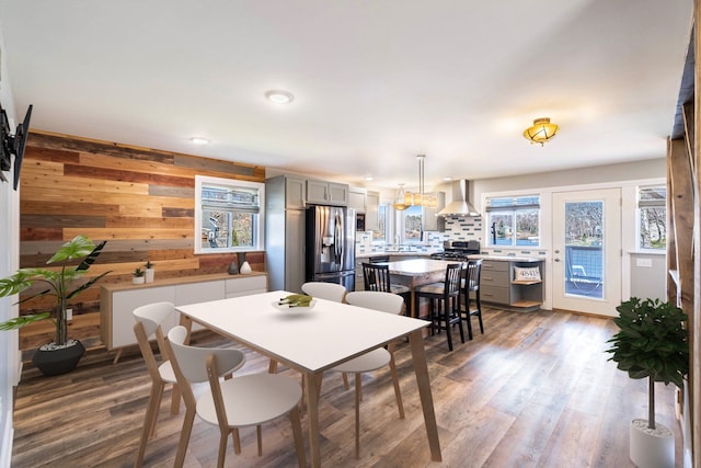 dining space featuring wood walls, dark wood-style flooring, and recessed lighting