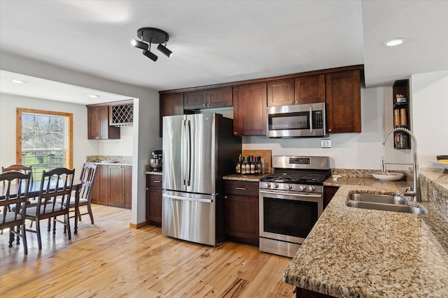 kitchen with recessed lighting, a sink, stainless steel appliances, light wood-style floors, and dark brown cabinets