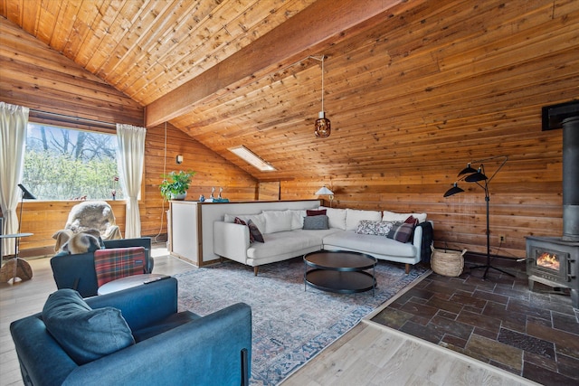 living room featuring lofted ceiling, wooden walls, a wood stove, and wood ceiling