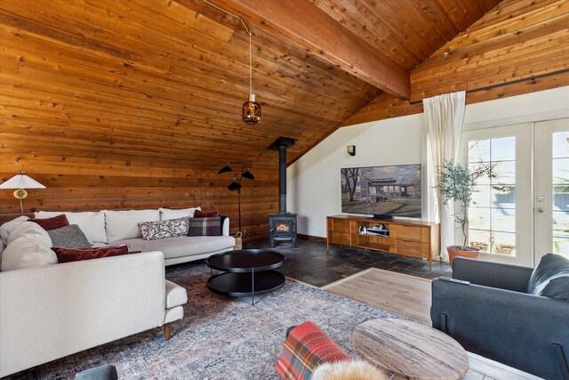 living area featuring a wood stove, vaulted ceiling with beams, wooden ceiling, and plenty of natural light