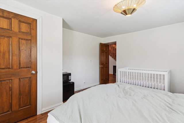 bedroom with wood finished floors and baseboards