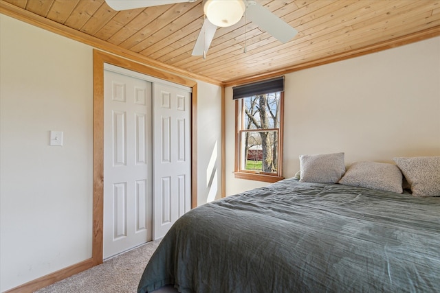 carpeted bedroom with a closet, crown molding, and wood ceiling