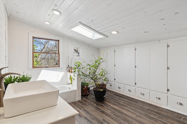 interior space featuring lofted ceiling with skylight, wood finished floors, recessed lighting, and wooden ceiling