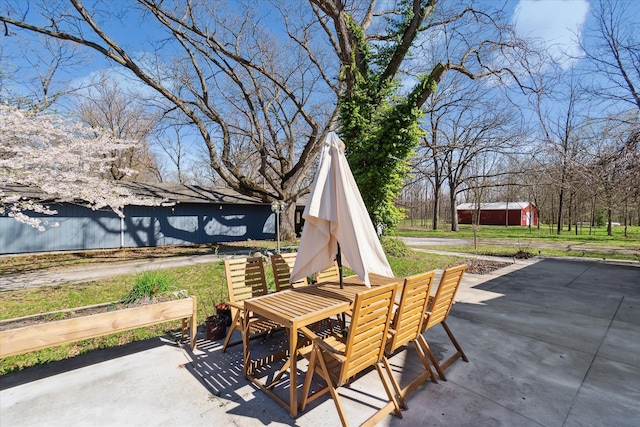 view of patio / terrace featuring an outbuilding, a storage shed, and outdoor dining area