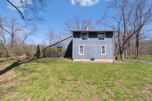 view of property exterior featuring a chimney and a lawn