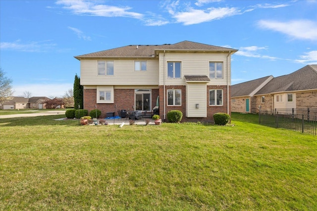 rear view of house with fence, a lawn, brick siding, and a patio