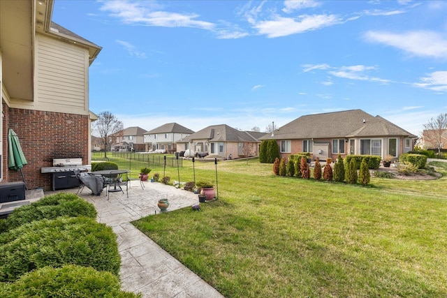view of yard with fence, a patio area, and a residential view