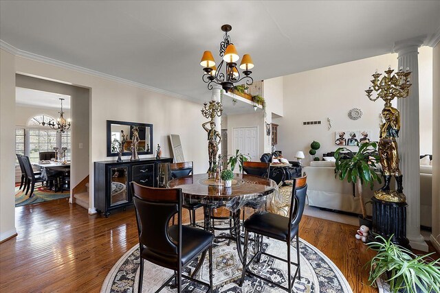 dining space with an inviting chandelier, crown molding, and wood finished floors