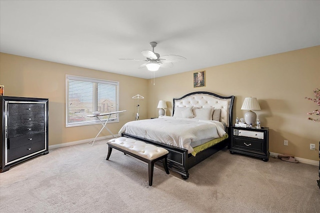 bedroom with ceiling fan, baseboards, and light colored carpet