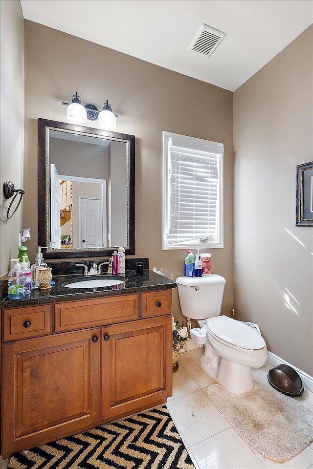 bathroom featuring visible vents, toilet, and vanity
