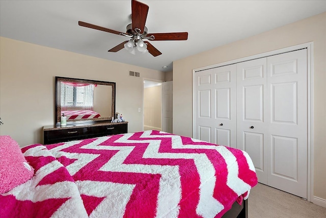 bedroom with a ceiling fan, visible vents, a closet, and light colored carpet