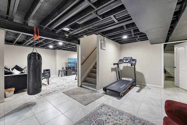exercise area with baseboards and tile patterned flooring