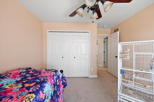carpeted bedroom featuring ceiling fan, baseboards, visible vents, and a closet