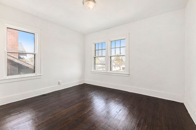 unfurnished room with dark wood-type flooring and baseboards