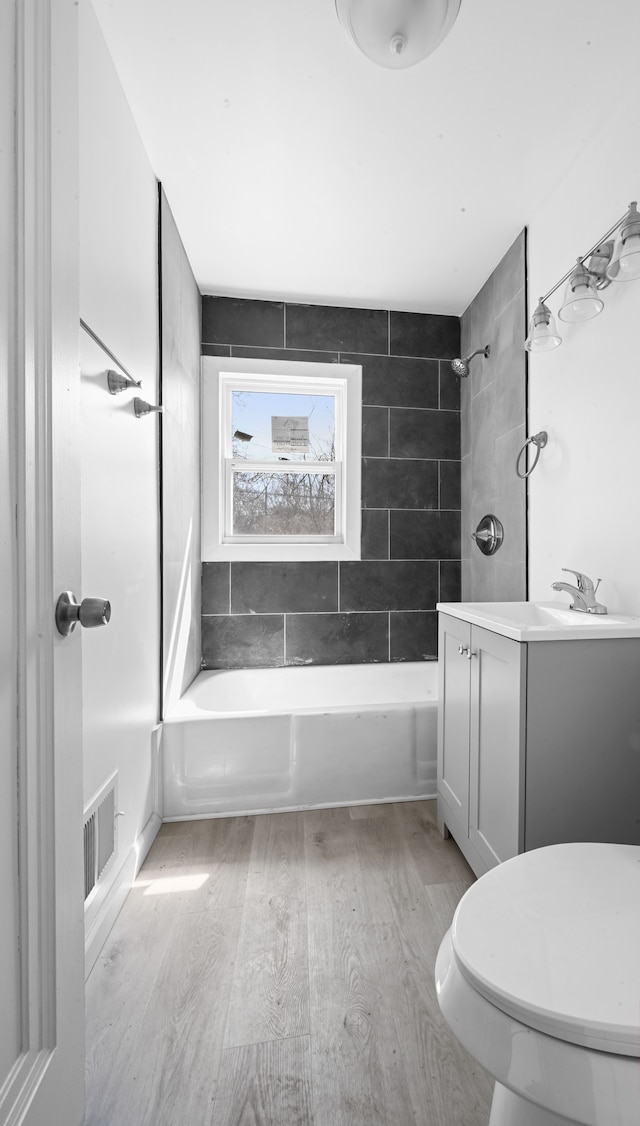 12816 Payton St, Detroit, MI 48224 - bathroom with visible vents, tub / shower combination, toilet, wood finished floors, and vanity