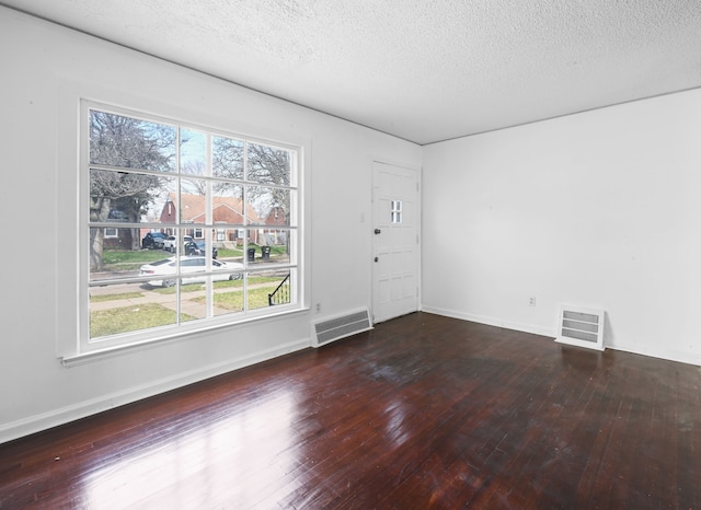 12816 Payton St, Detroit, MI 48224 - unfurnished room featuring a textured ceiling, visible vents, hardwood / wood-style floors, and baseboards