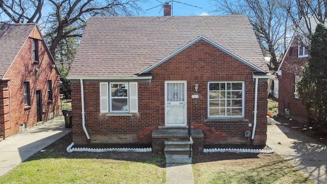 12816 Payton St, Detroit, MI 48224 - view of front facade featuring a chimney, a shingled roof, and brick siding