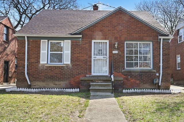 12816 Payton St, Detroit, MI 48224 - bungalow-style home with brick siding, a shingled roof, and a front yard
